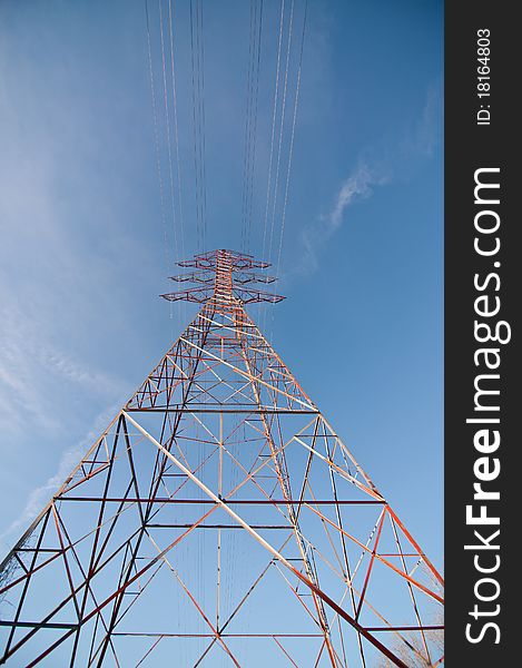 An electrical transmission tower carrying high voltage lines beside a lake in winter. An electrical transmission tower carrying high voltage lines beside a lake in winter.