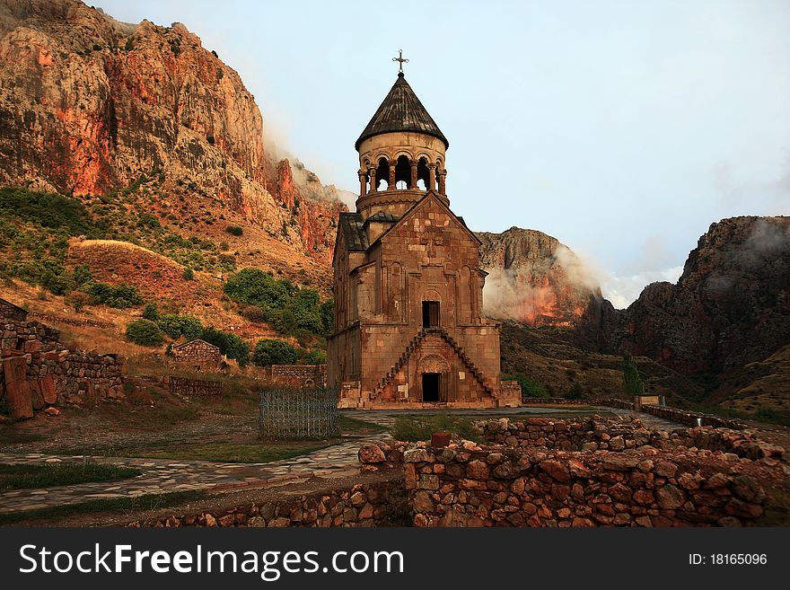 The red church in a mountain gorge in Armenia. The beautiful rotunda and a conical dome is crowned by a masterpiece of Armenian architecture of the 14 th century