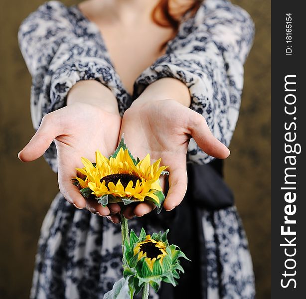 An image of young woman with sunflower