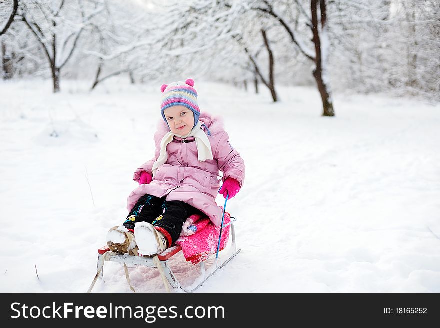 An image of a child sitting on sledge. An image of a child sitting on sledge
