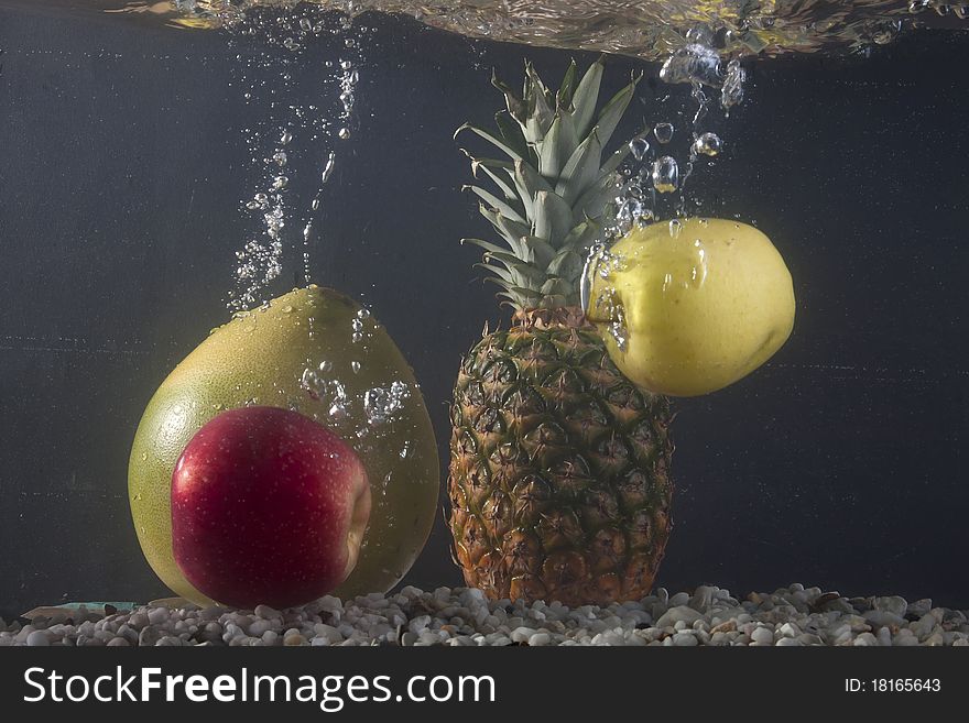 Various fruit under water on a dark background. Various fruit under water on a dark background