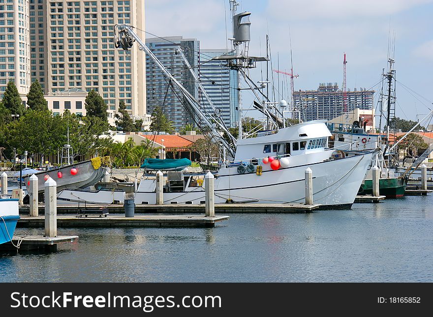 Fishing vessels and modern buildings at the marina in San Diego CA. Fishing vessels and modern buildings at the marina in San Diego CA.