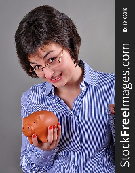 Young woman trying to get money from her piggy bank