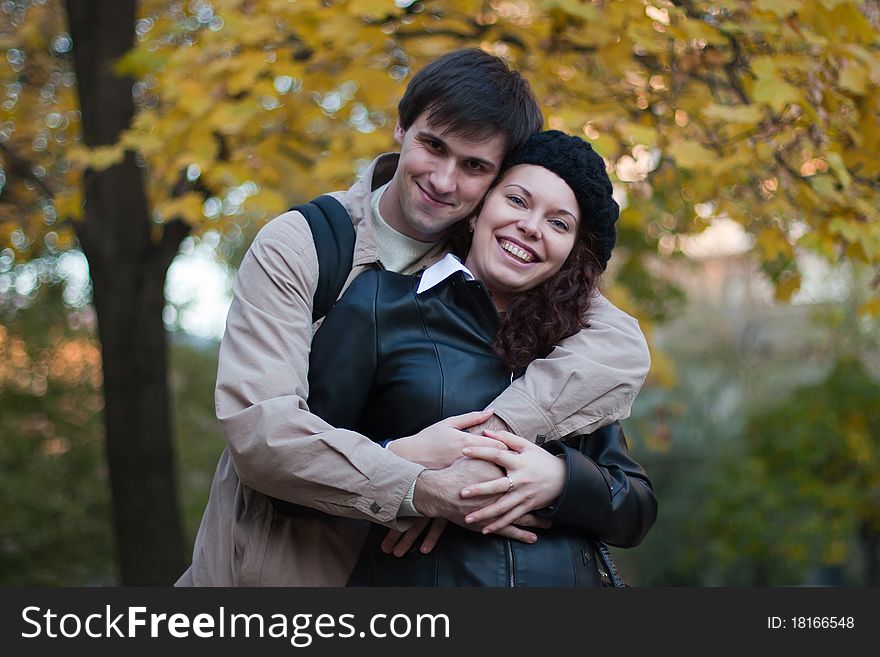 Smiling male and female in autumn park