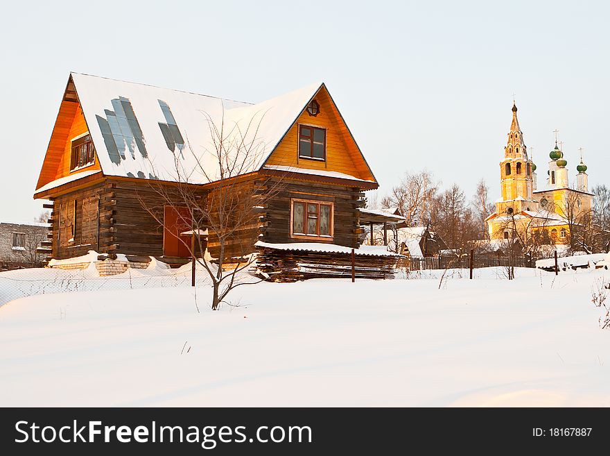 New house and old church in winter sunset light