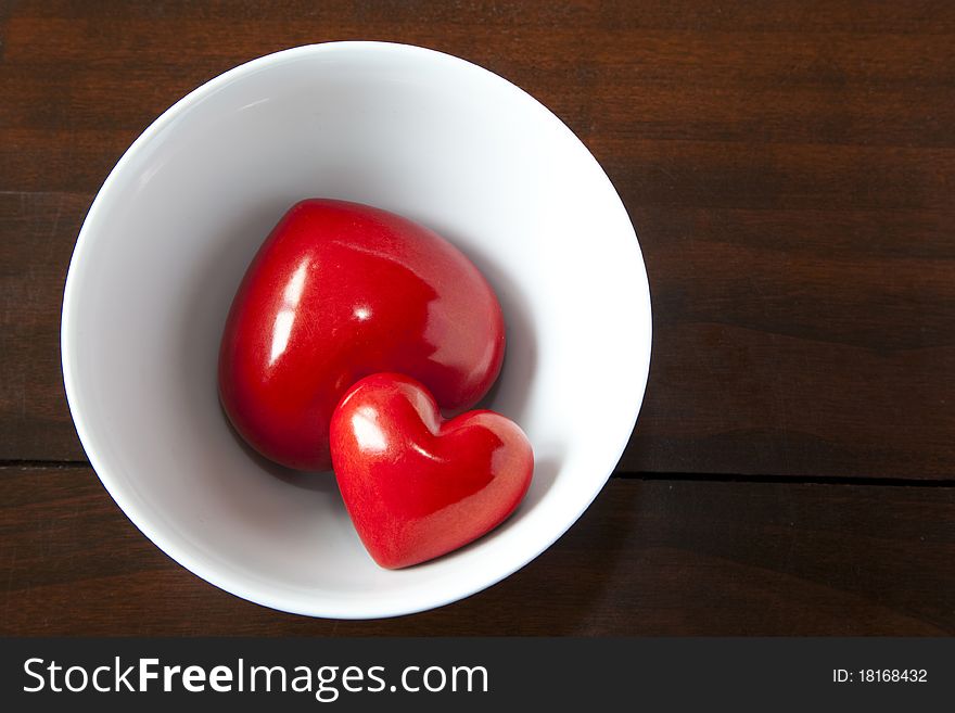 Two red hearts are in a bowl
