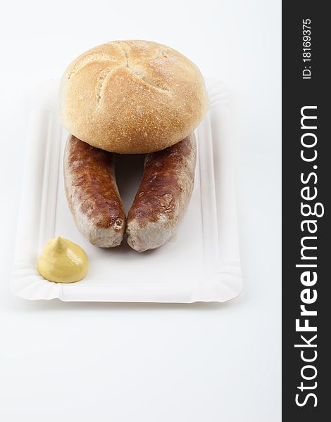 A pair of fried sausages with mustard