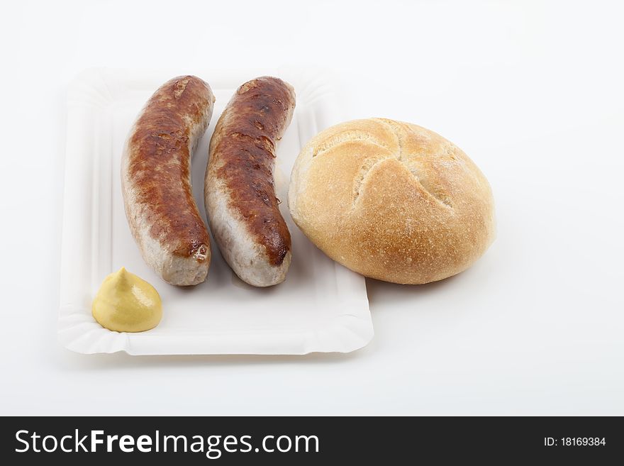 A pair of fried sausages with mustard
