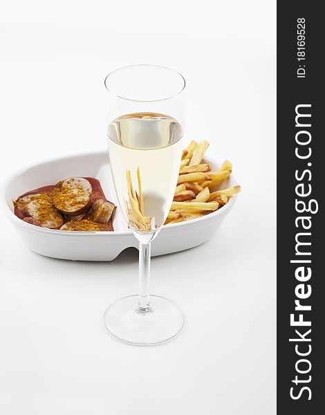 Curried sausages french fries and a glass of prosecco on white background. Curried sausages french fries and a glass of prosecco on white background