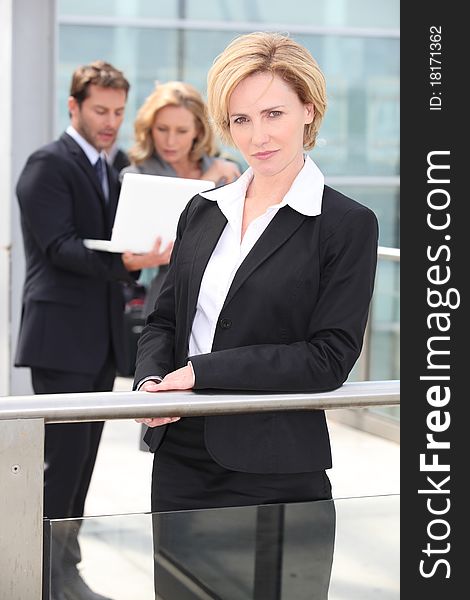 Mature businesswoman standing outdoors in foreground. Mature businesswoman standing outdoors in foreground