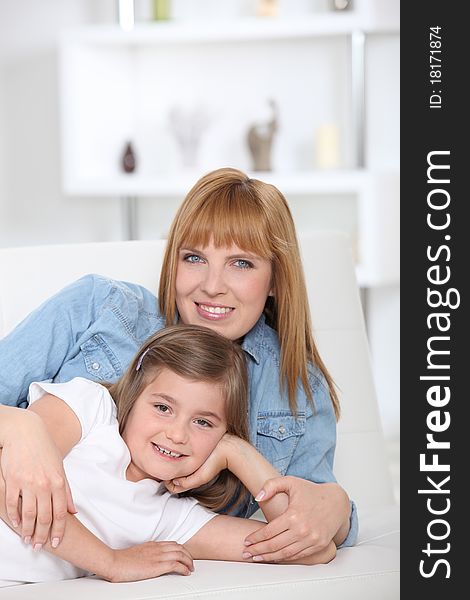 Woman and girl laid on a sofa. Woman and girl laid on a sofa