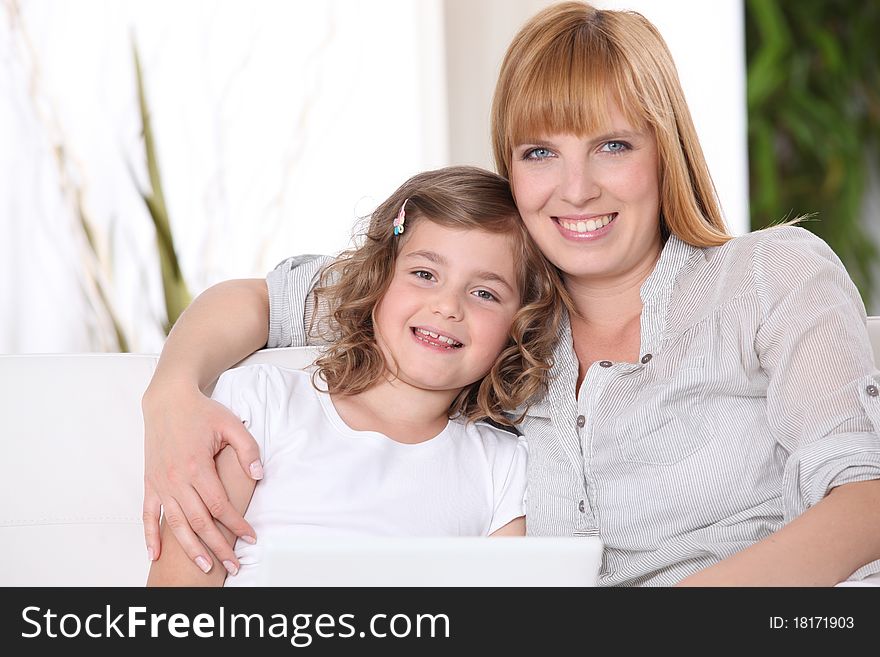 Woman and little girl in front of a laptop computer. Woman and little girl in front of a laptop computer