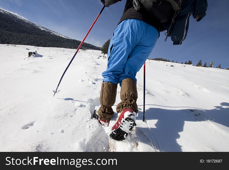 Hiker in winter in mountains climbing to the peak