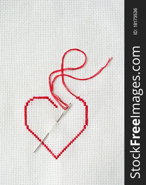 Embroidered red heart on white canvas. Embroidered red heart on white canvas