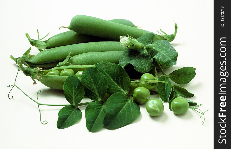 Group of green peas with foliage and flower