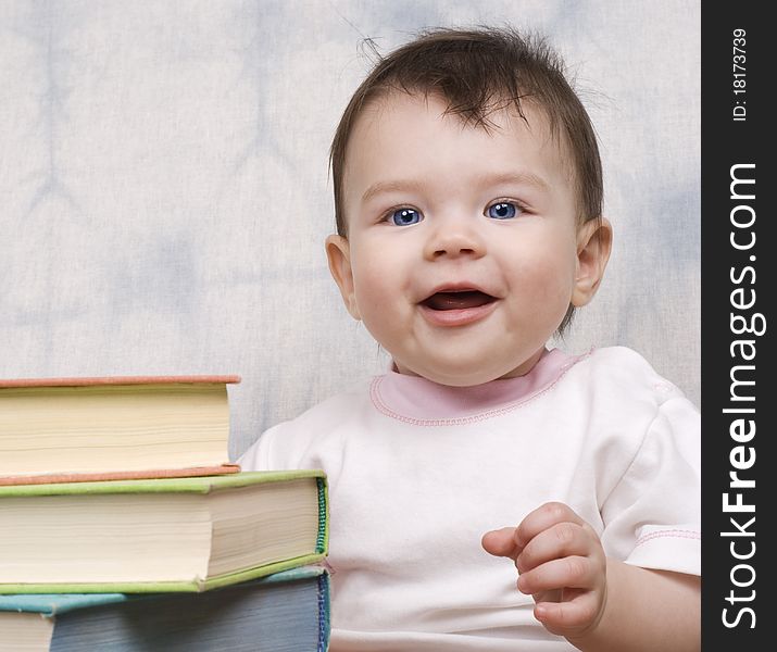 The small child with books on a light background