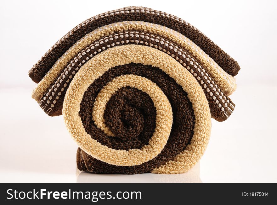 Rolled up brown bath towels . Rolled up brown bath towels .