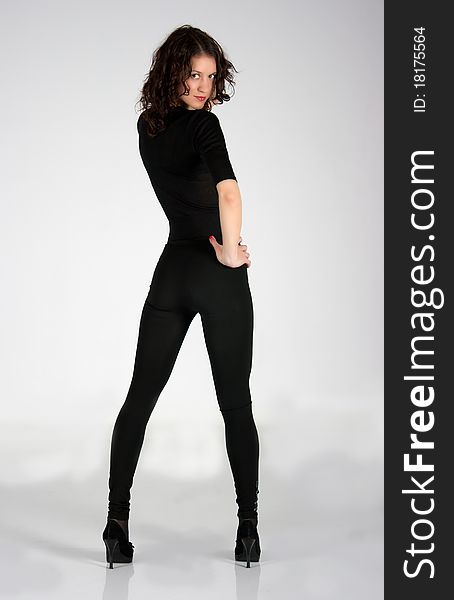 Adult young woman in black clothes posing in the studio