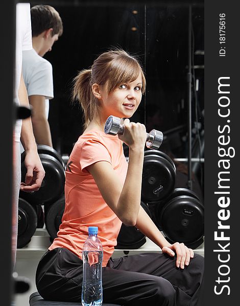 Young woman with dumbbell in fitness club. Young woman with dumbbell in fitness club