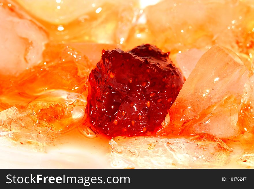 Red strawberry jam and some pieces of yellow ice. Red strawberry jam and some pieces of yellow ice