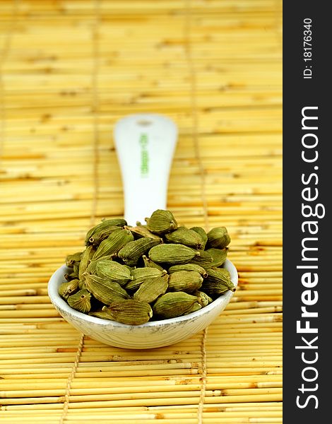 Green cardamom seeds in a tablespoon