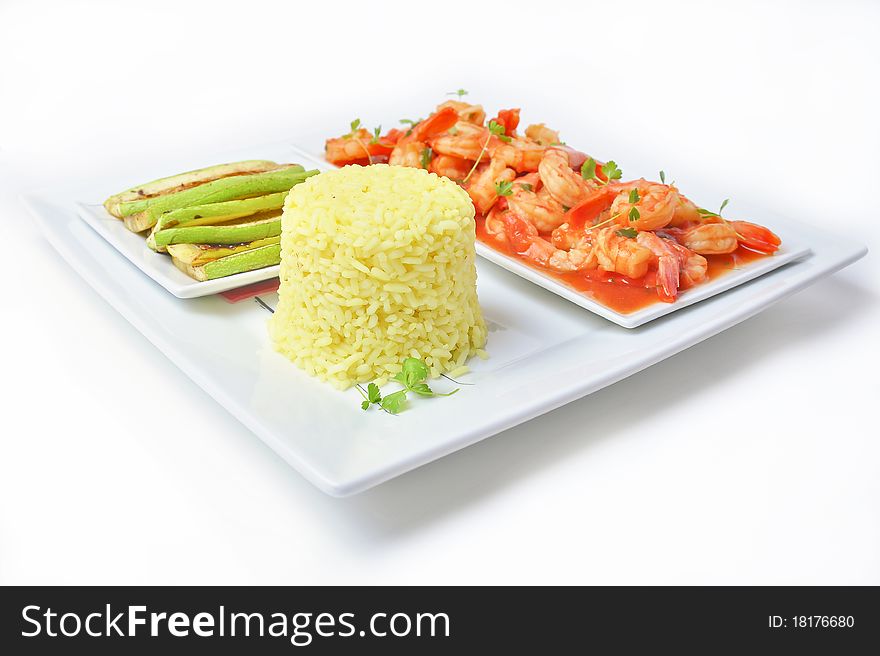 Shrimps in tomato sauce with rice and zuchinni on white plate and background.