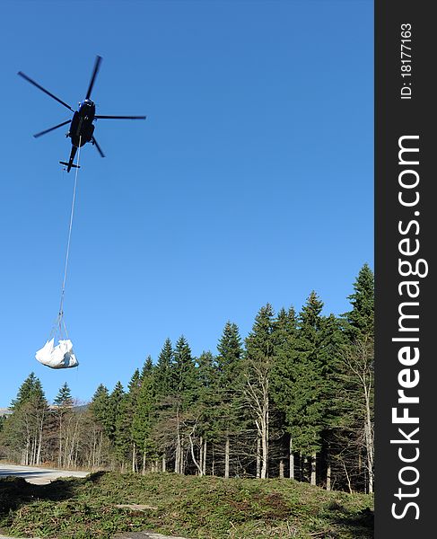 Helicopter with load. Branchers from mountain.