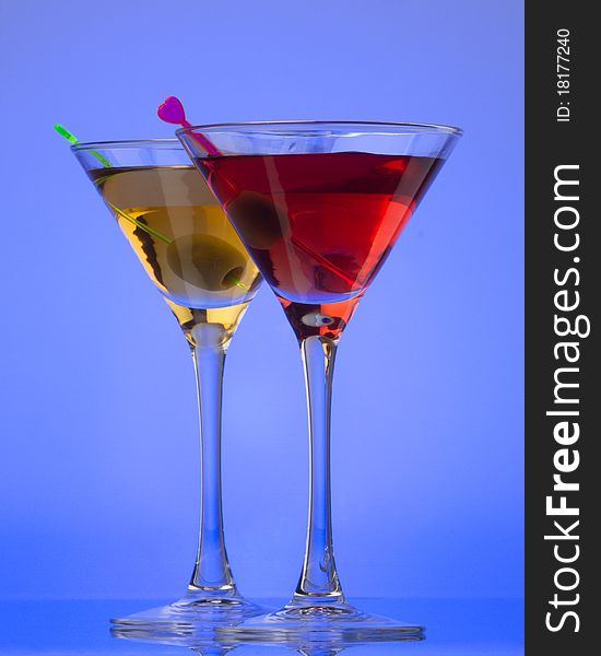 Cocktail with olive on a blue