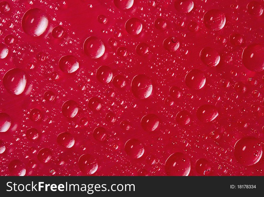 Many drops of water on red background