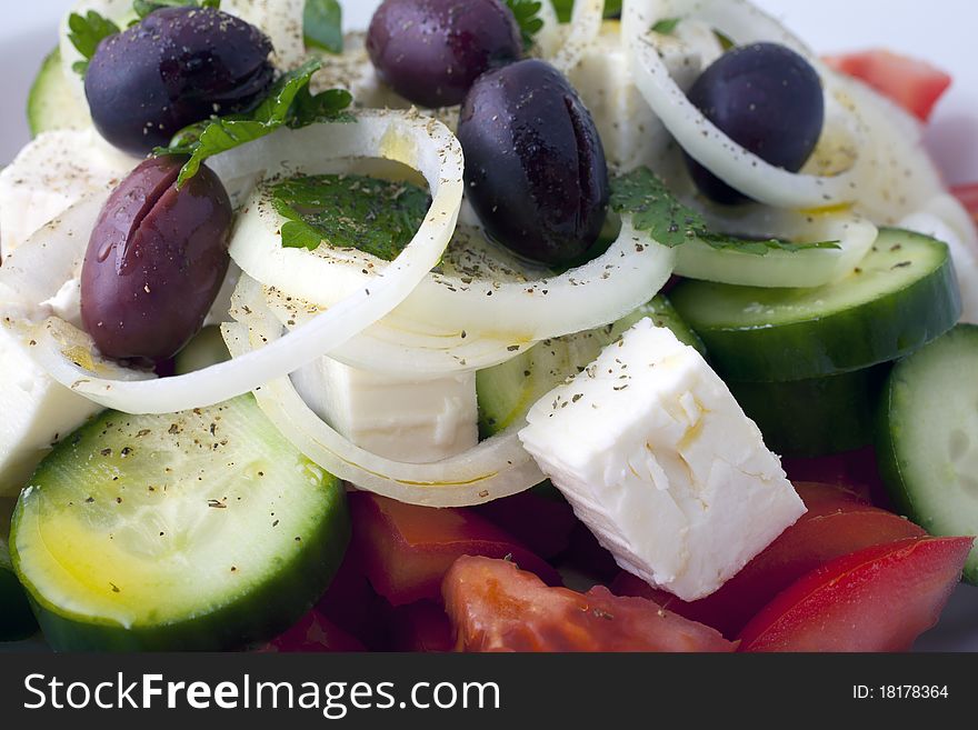 Greek salad inside a white plate and a white background