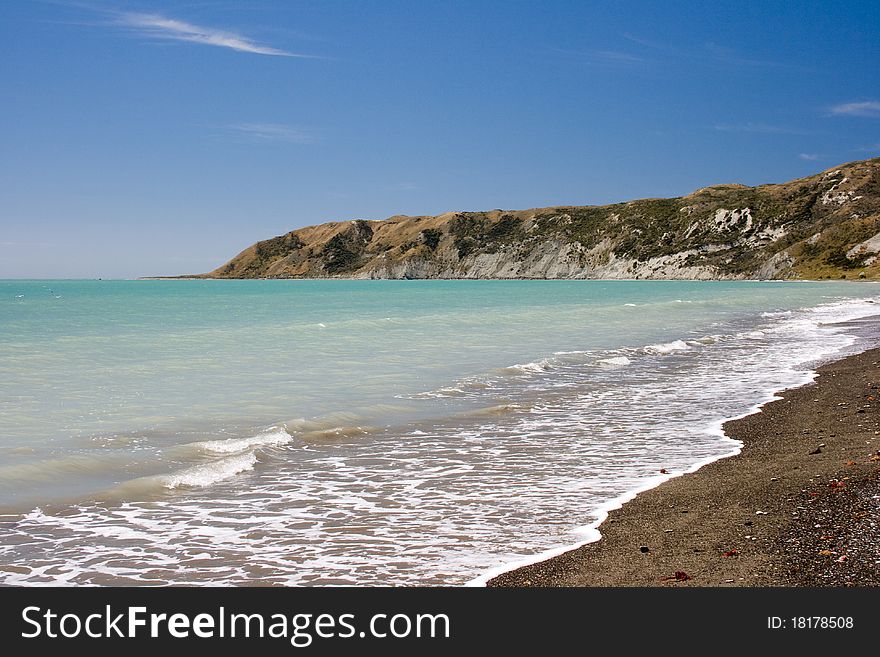 Gravel Beach With Cliff On Background