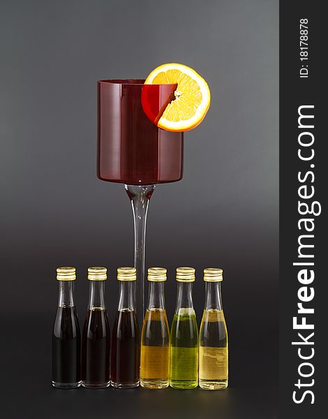 Red Liquor Glass with Orange slice and small liquor bottles