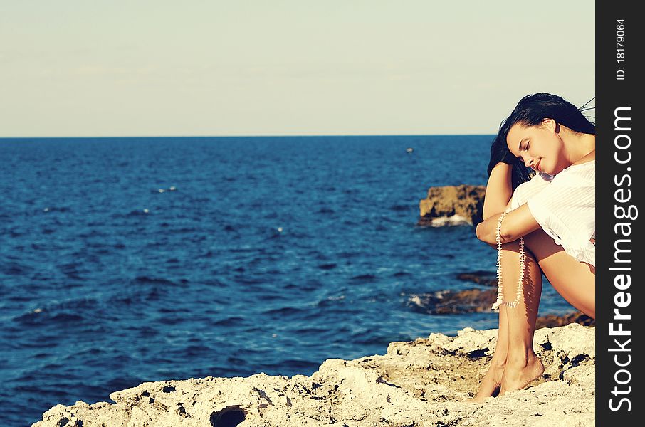 Stylized photo of young woman on the beach