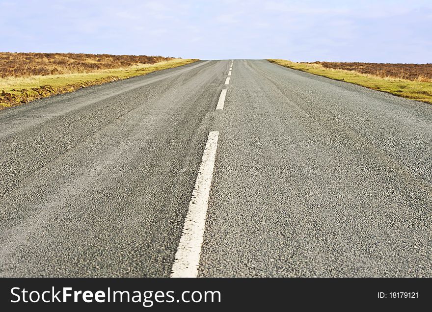 Single lane road in the countryside heading towards horizon. Single lane road in the countryside heading towards horizon