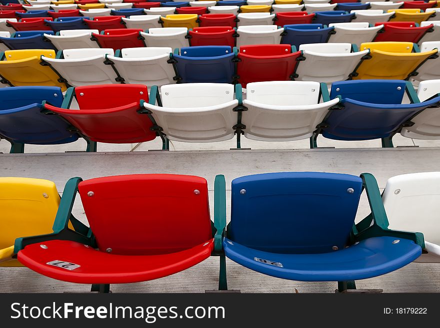 Rows of colored seats at an outdoor venue. Rows of colored seats at an outdoor venue