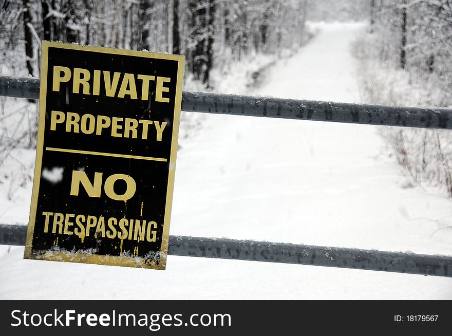 No trespassing sign down peaceful snowy winter lane. No trespassing sign down peaceful snowy winter lane