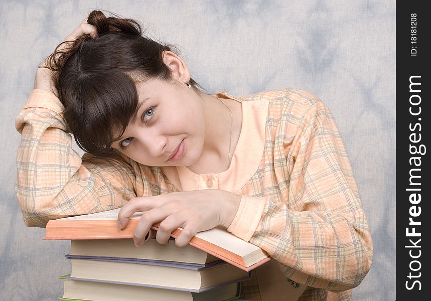 The young girl with books on a light background
