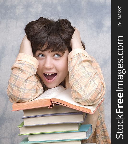 The young girl with books on a light background