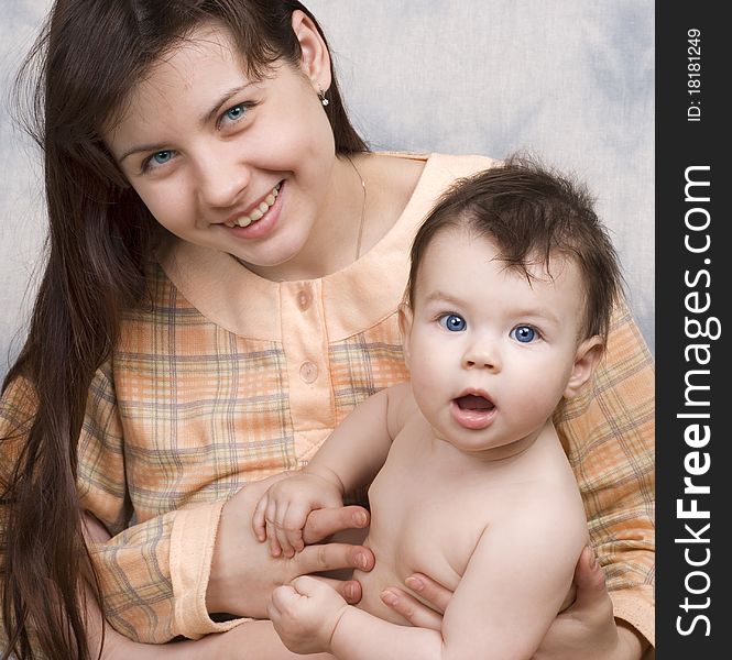 The young woman with the child on light a background