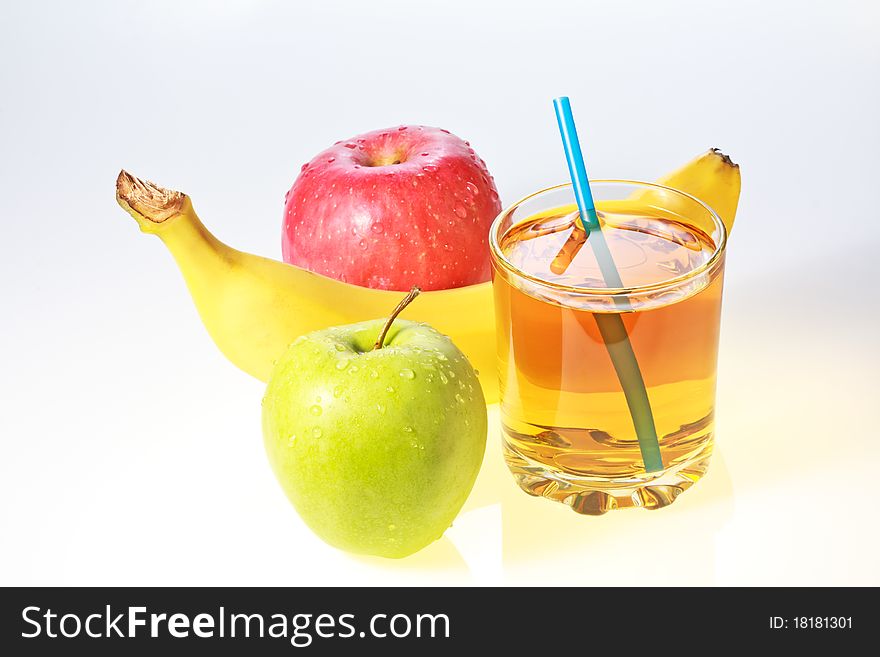 Banana, green and red apples and glass of apple juice with drinking straw. Banana, green and red apples and glass of apple juice with drinking straw