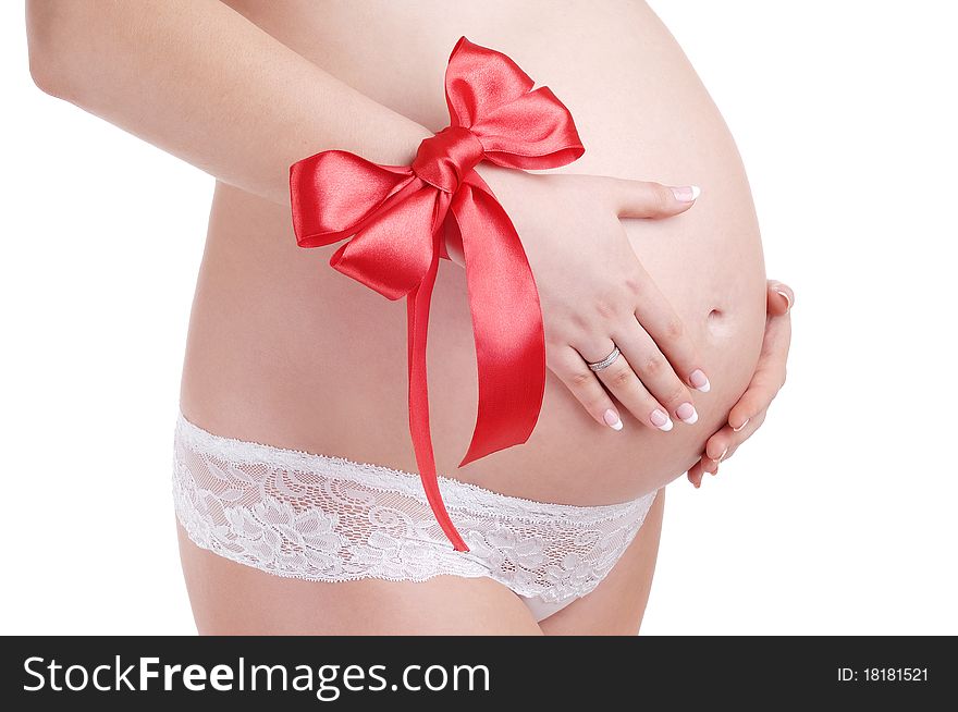 Pregnant woman belly and red bow isolated on a white background. Pregnant woman belly and red bow isolated on a white background