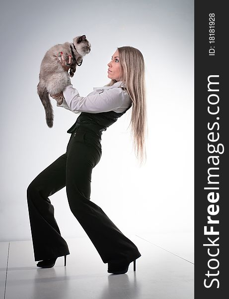 Young beautiful woman with cat, trousered blond girl , studio glamour portrait. Young beautiful woman with cat, trousered blond girl , studio glamour portrait