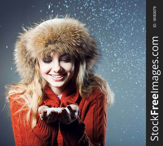 Young beautiful girl rejoices to snow, On a dark blue background