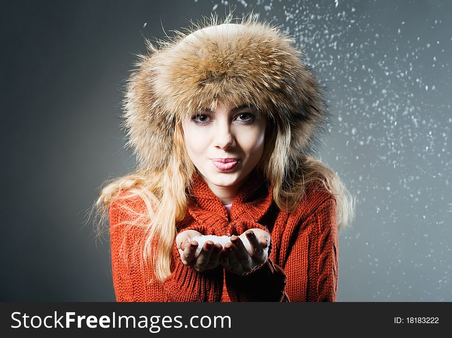 Young beautiful girl rejoices to snow, On a dark blue background