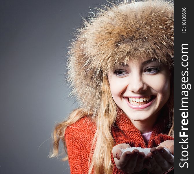 Young beautiful girl rejoices to snow, On a dark blue background