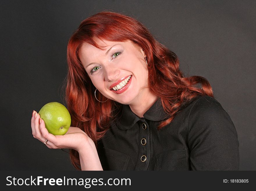 Portrait of happy redheaded beautiful woman with an apple in a studio. Portrait of happy redheaded beautiful woman with an apple in a studio