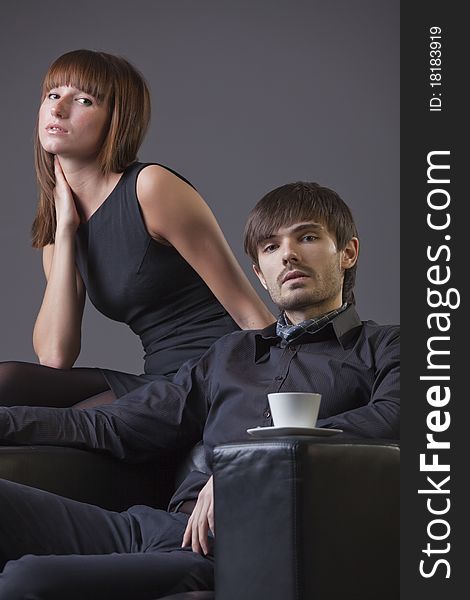 Fashion couple portrait in studio over grey background