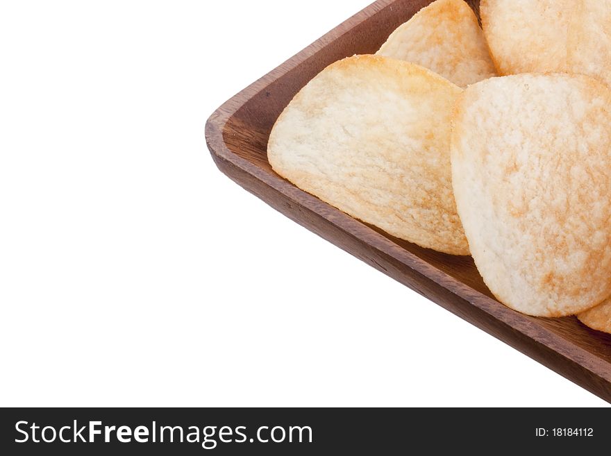 Potato chips from organic products in a wooden plate.