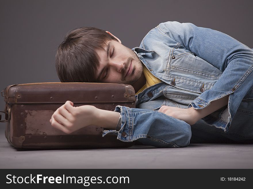 Man sleeping on suitcase waiting for travel