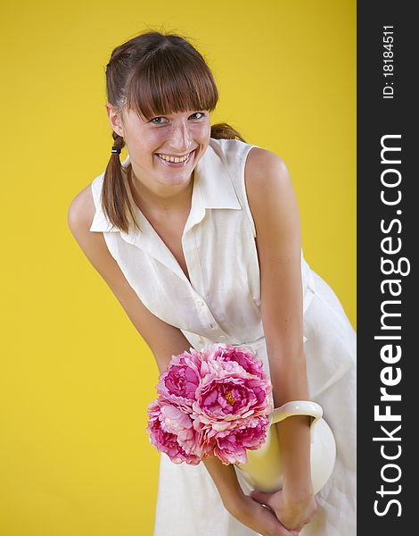 Happy summer woman holding vase with flowers over yellow background. Happy summer woman holding vase with flowers over yellow background